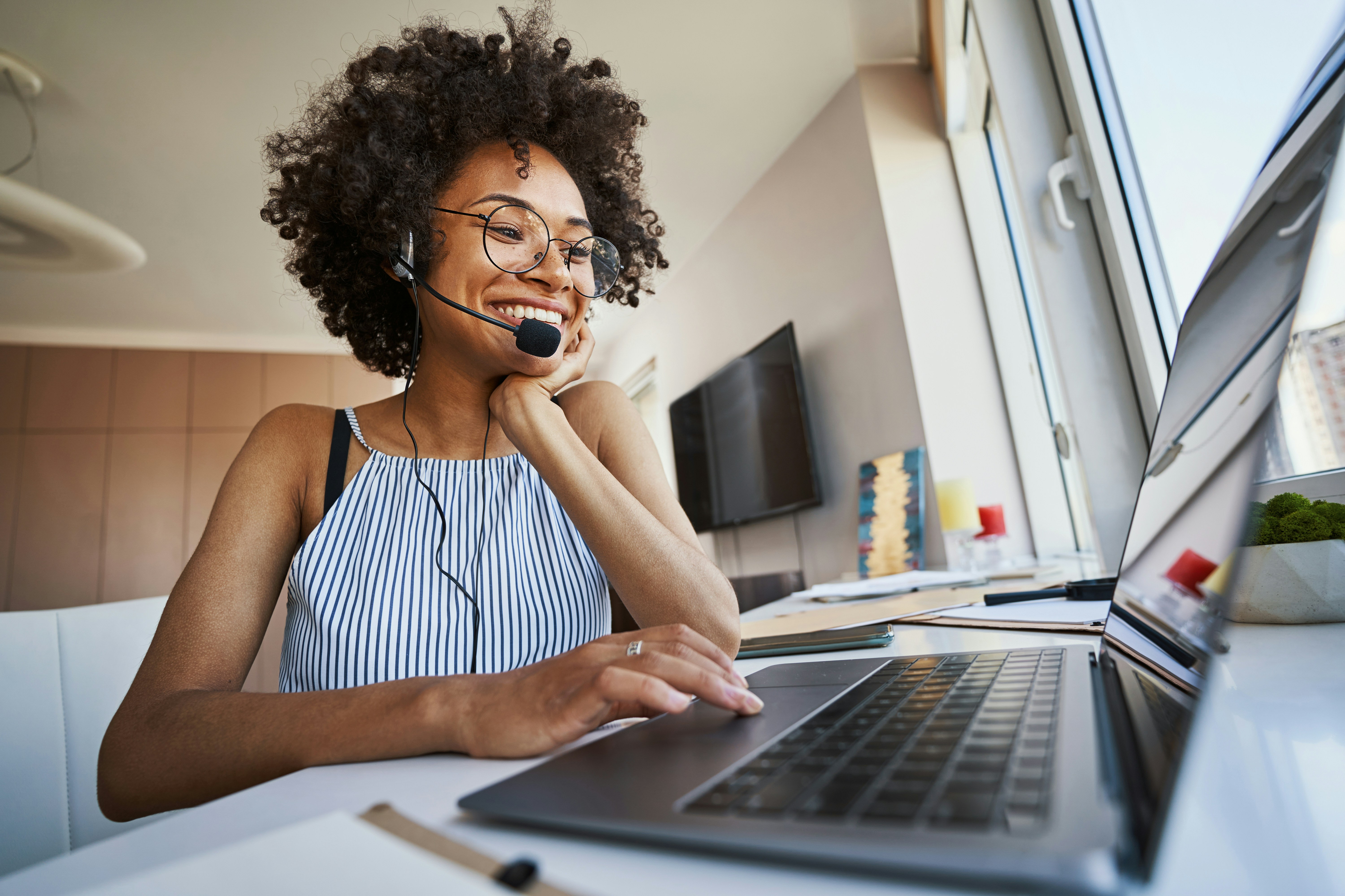 woman wearing a headset working at her laptop